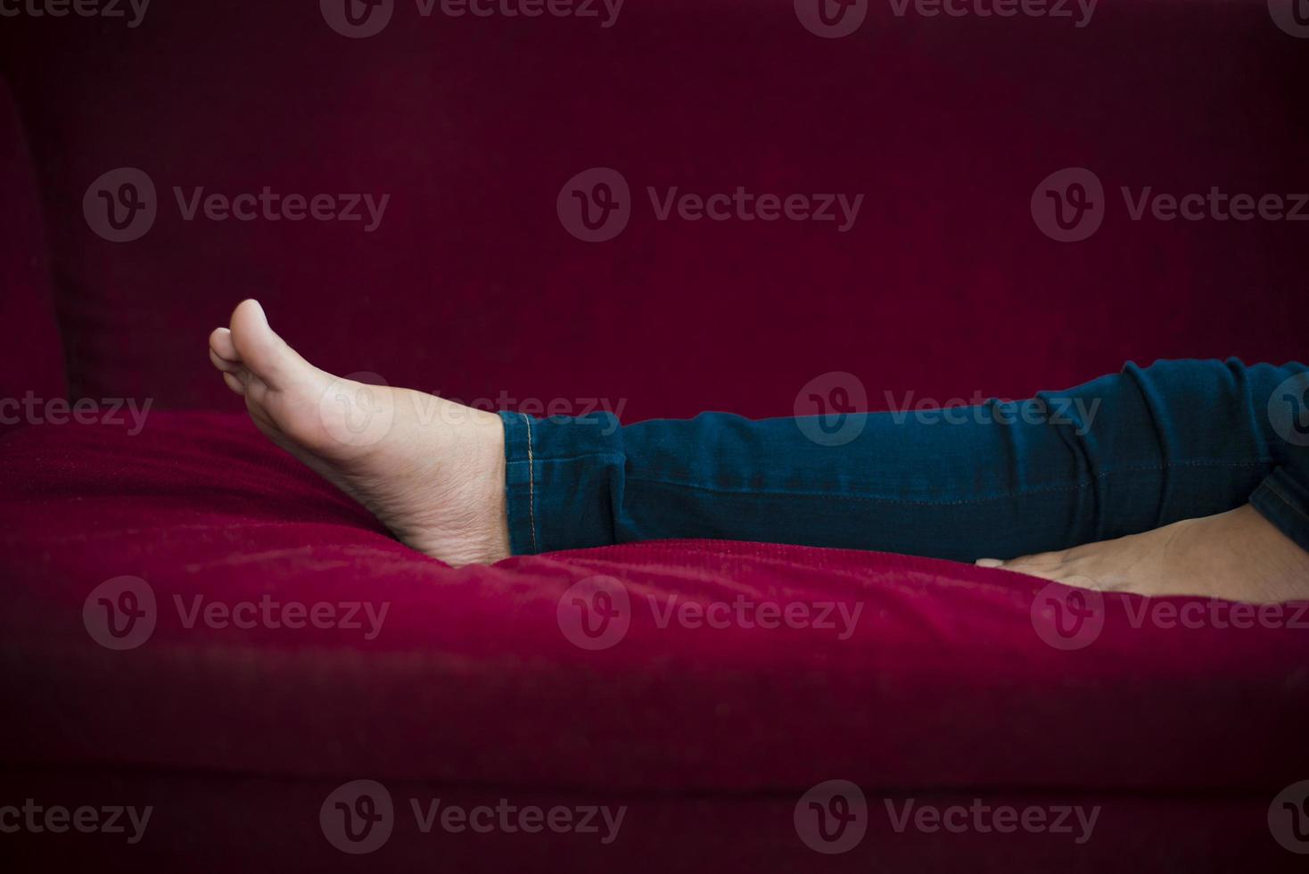 kvinna ben med jeans medan du kopplar av på bio foto