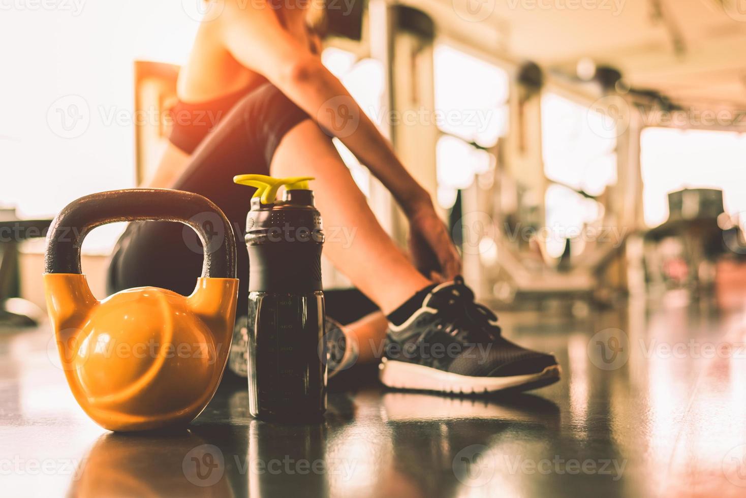 närbild kettlebells med kvinnans träningspass i gymmet foto