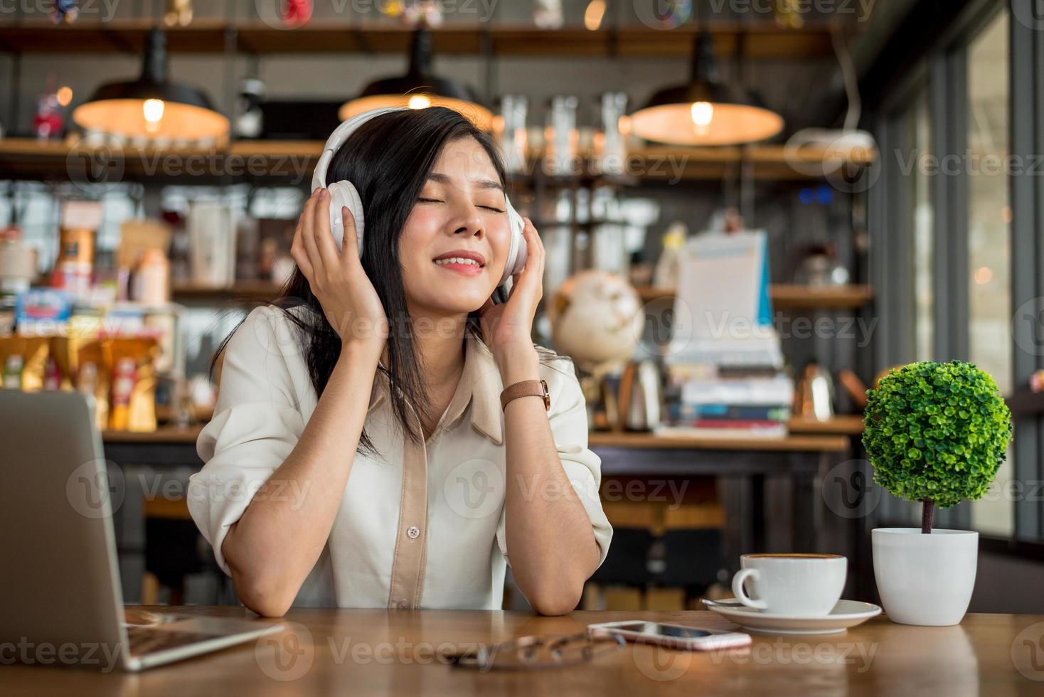 glad asiatisk kvinna som kopplar av och lyssnar på musik foto