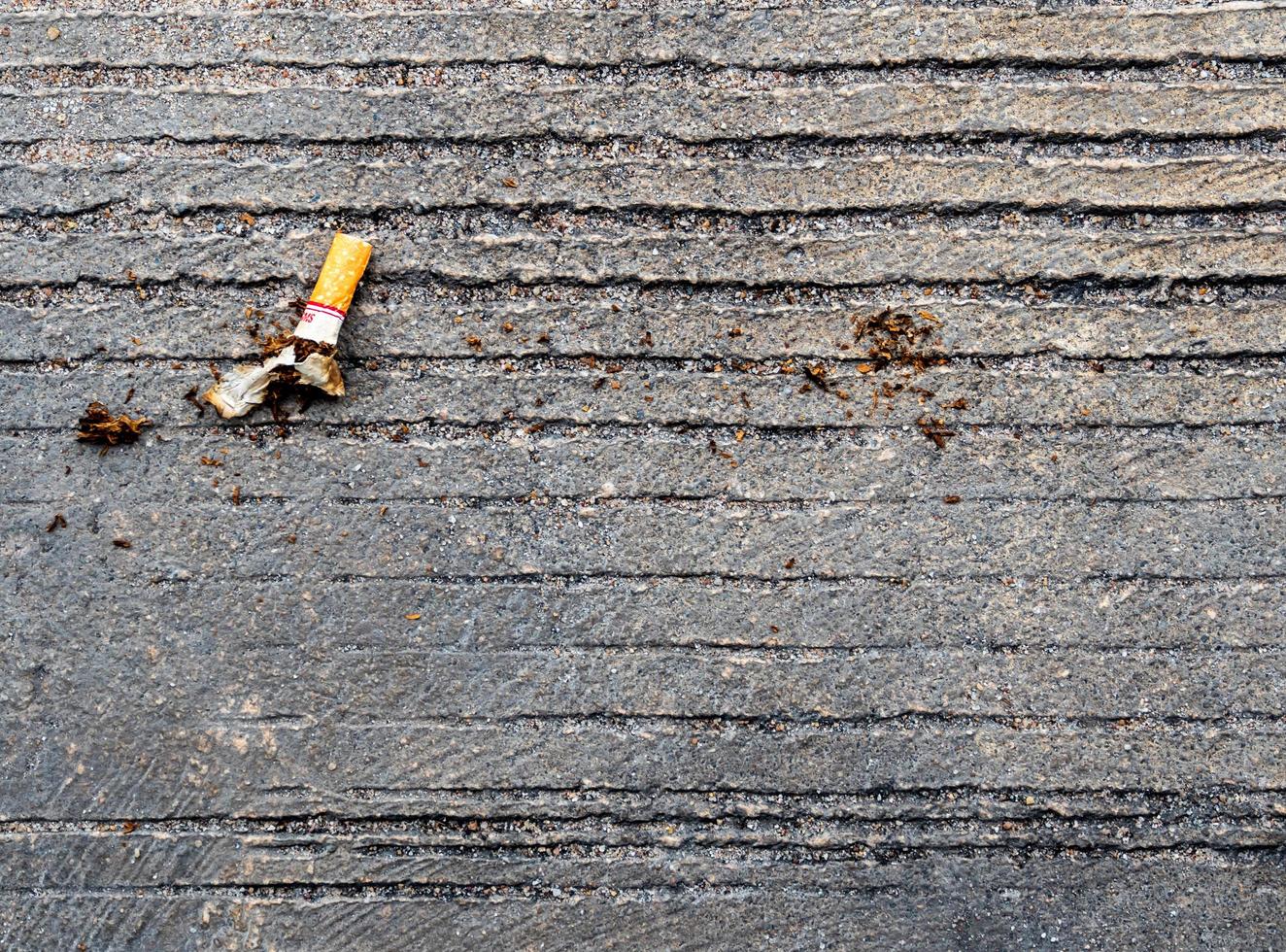 cigarettstumpen släpptes på betonggolvet foto