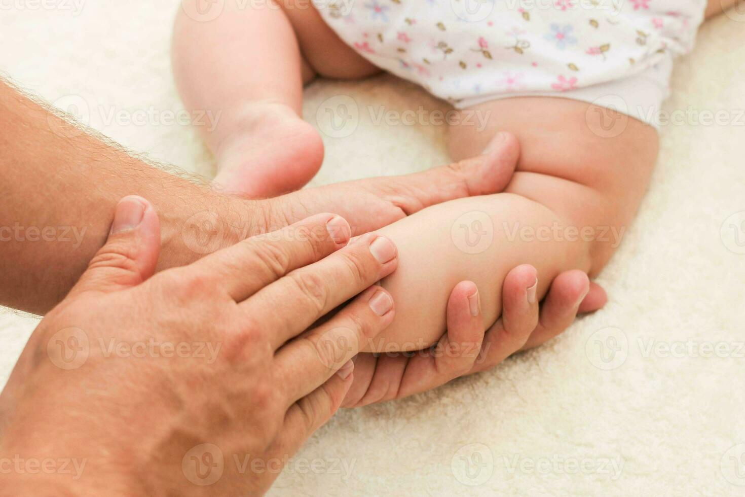 massör håller på med massage för fot liten bebis foto