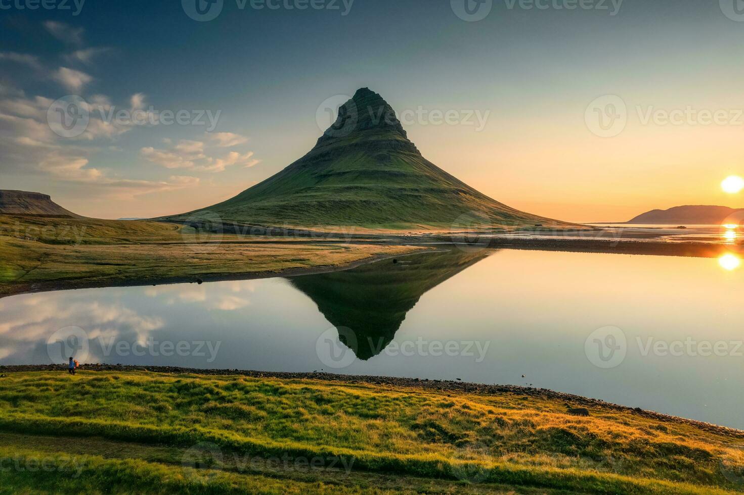 vulkanisk Kirkjufell berg med sjö reflexion och resande man stående under soluppgång på island foto