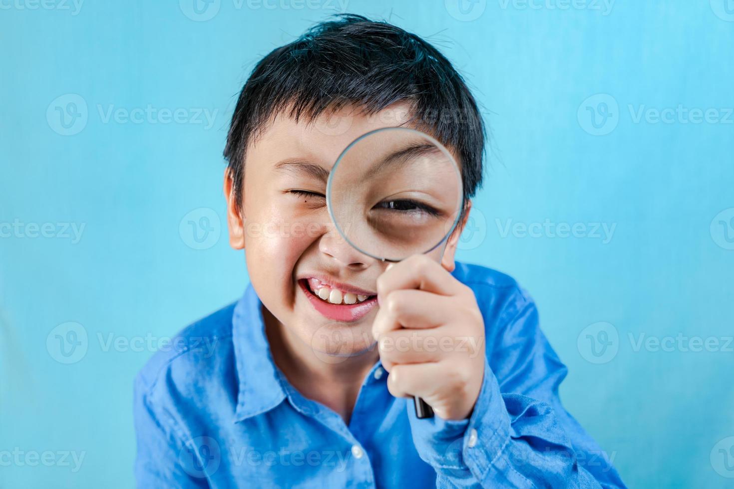liten pojke som håller förstoringsglas foto