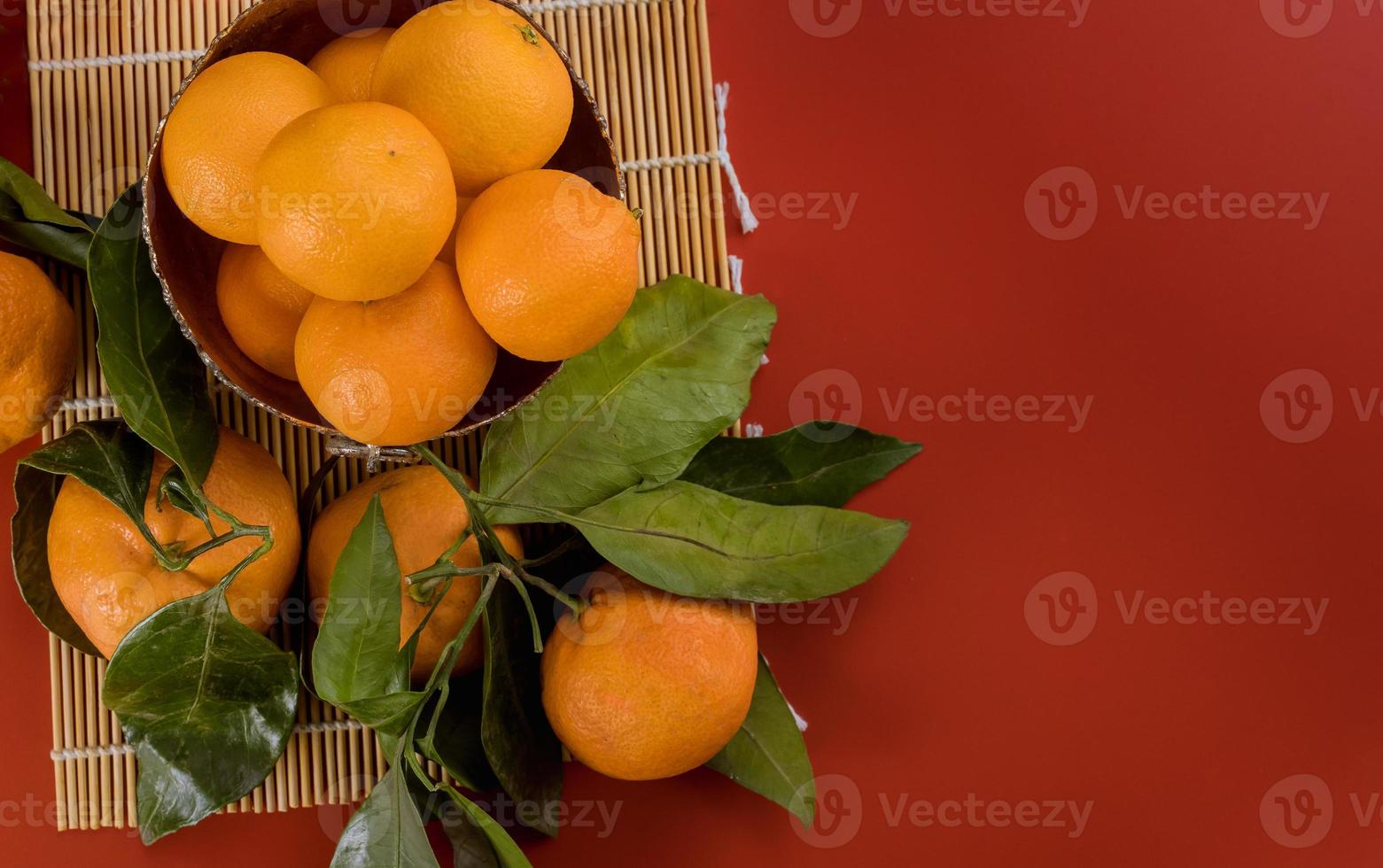 mandarin apelsin med grönt blad med korg isolerad på röd bakgrund foto
