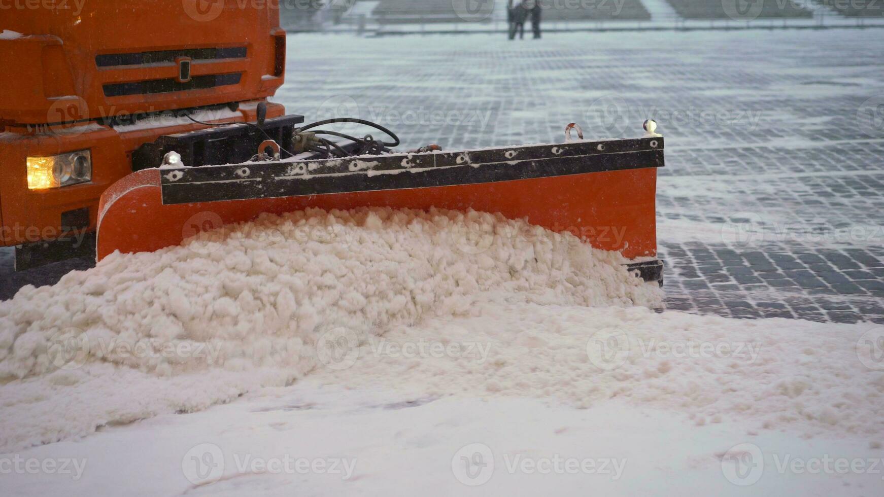 de traktor rengör de trottoar i vinter. traktor rengöring de väg från de snö. grävmaskin rengör de gator av stor belopp av snö i stad. en hink närbild rengör de trottoar från snö. foto