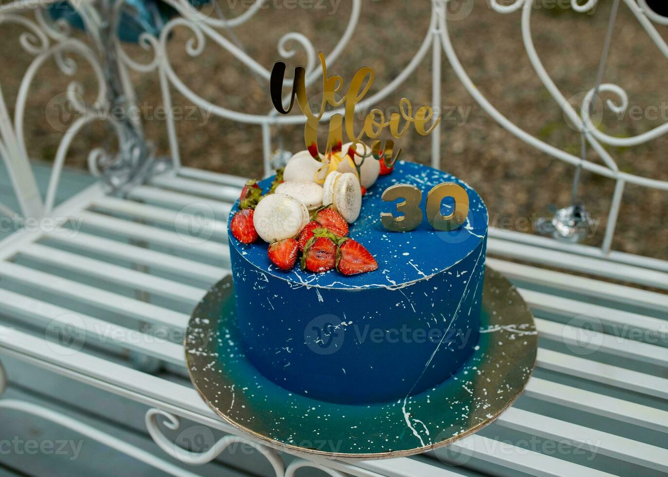 30 år årsdag blå kaka med jordgubbar på gyllene tallrik foto
