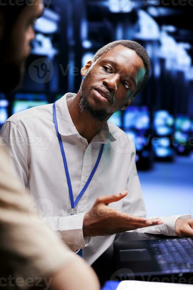 afrikansk amerikan expert- och kollega som handlar om med server rum systemet misslyckanden. dator vetenskapsmän brainstorming sätt till minimera data Centrum Utrustning driftstopp och förhindra kraschar foto