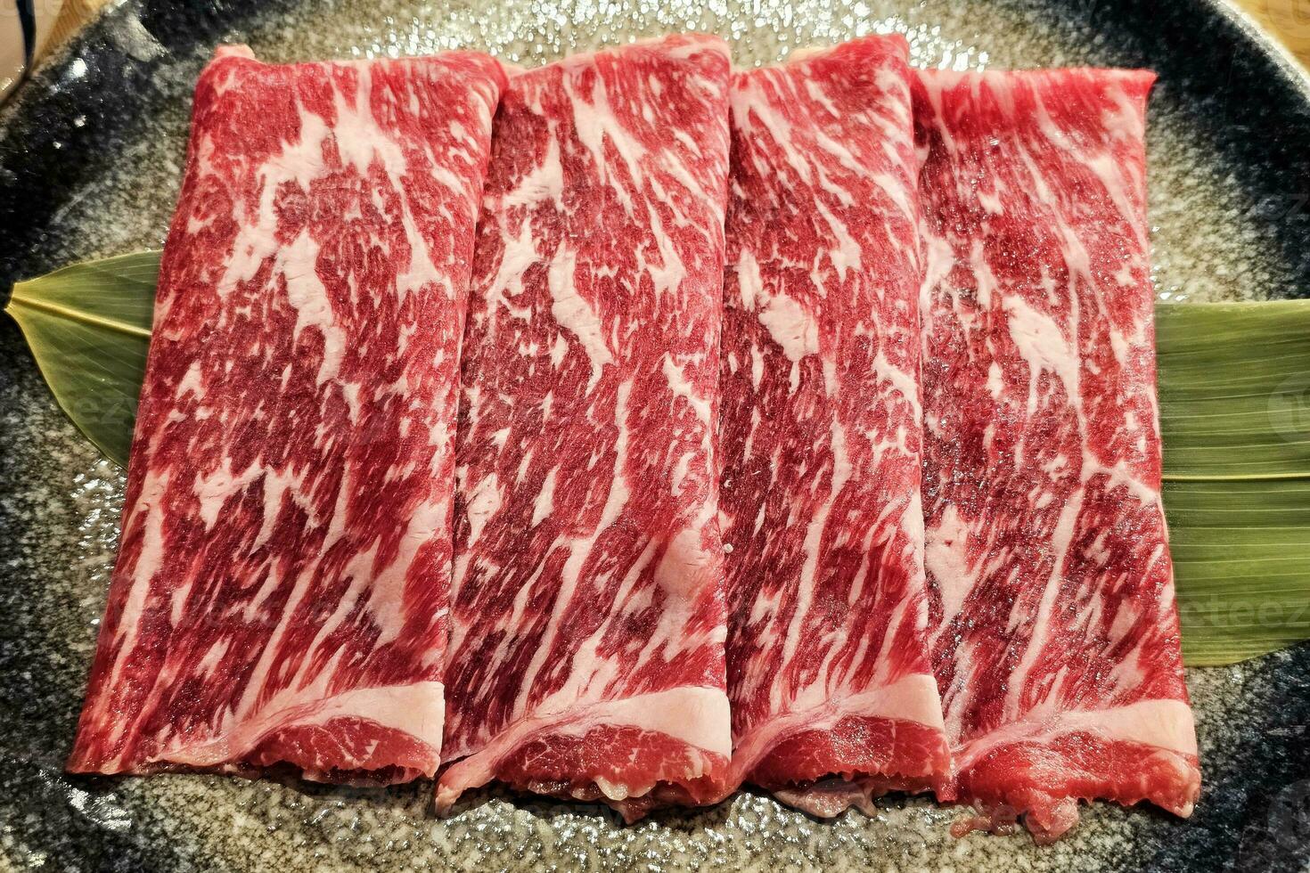 stänga upp skivad wagyu marmorerad nötkött i tallrik. foto