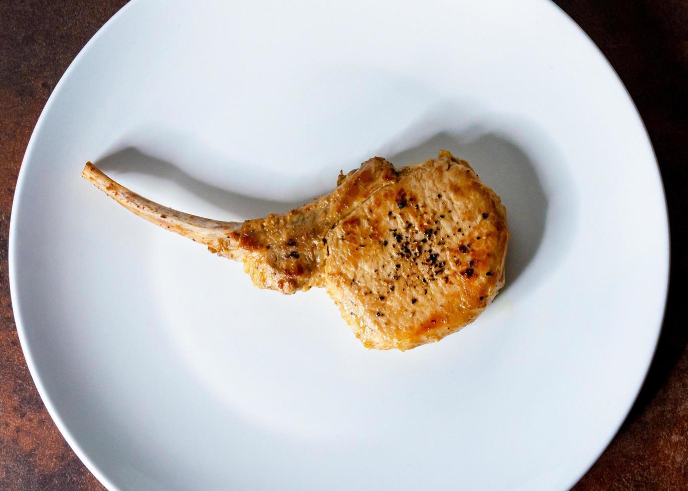 rostad fläskkotlett, grillad fläskkarré serverad i en vit rätt foto