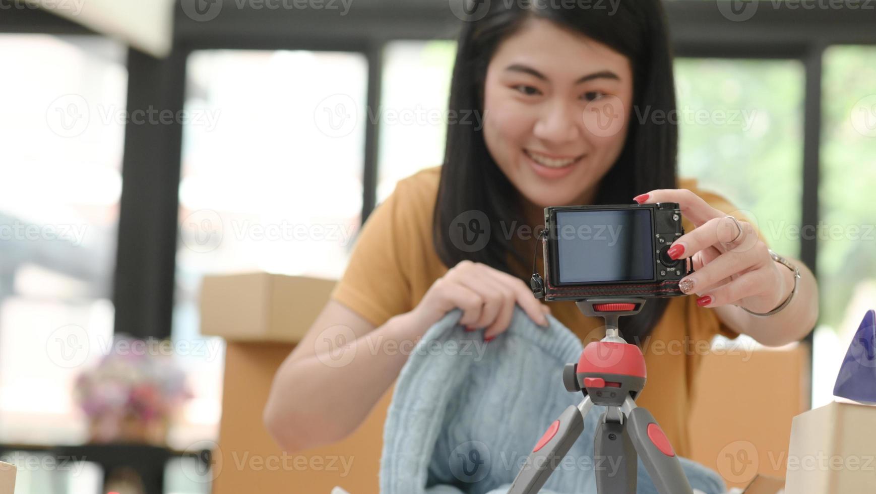 le kvinna slår på en kamera för att sälja online. foto
