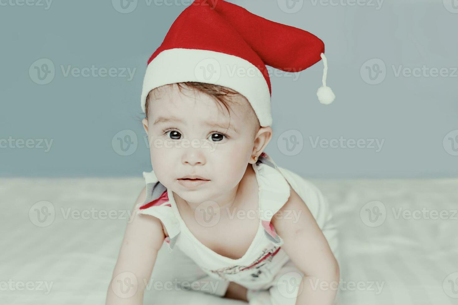 liten tomten. 1-åring bebis flicka i santa claus hatt. glad jul. förtjusande Mellanöstern flicka i santa keps. foto