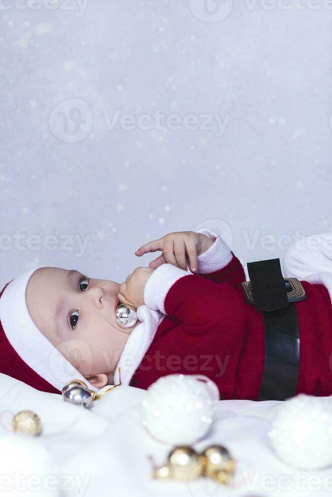 liten tomten. 6-9 månader gammal bebis pojke i santa claus kostym. glad jul foto