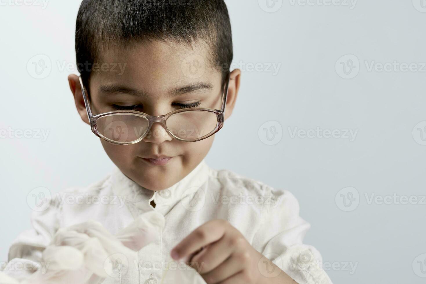 liten pojke forskare i labb täcka och glasögon foto