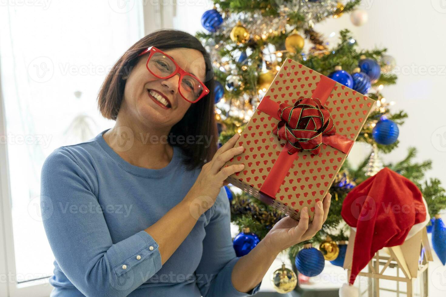 skön Lycklig kvinna på Hem i de jul atmosfär bland träd och gåvor foto