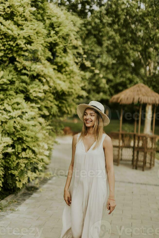 ung kvinna med hatt promenader i resort trädgård foto