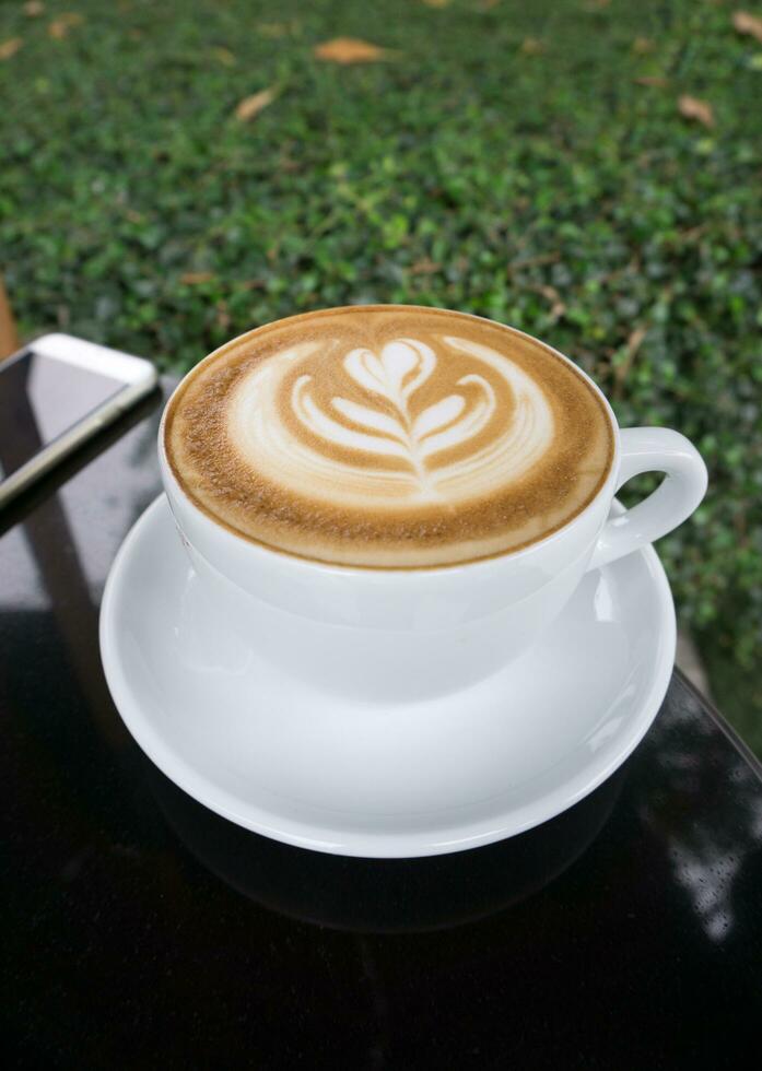 koppar av latte konst kaffe på svart tabell foto