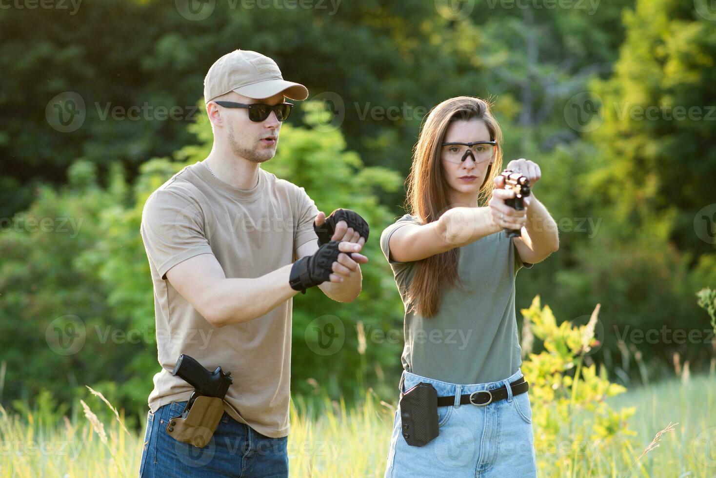 en flicka lär till skjuta en pistol med ett instruktör på de Träning jord foto