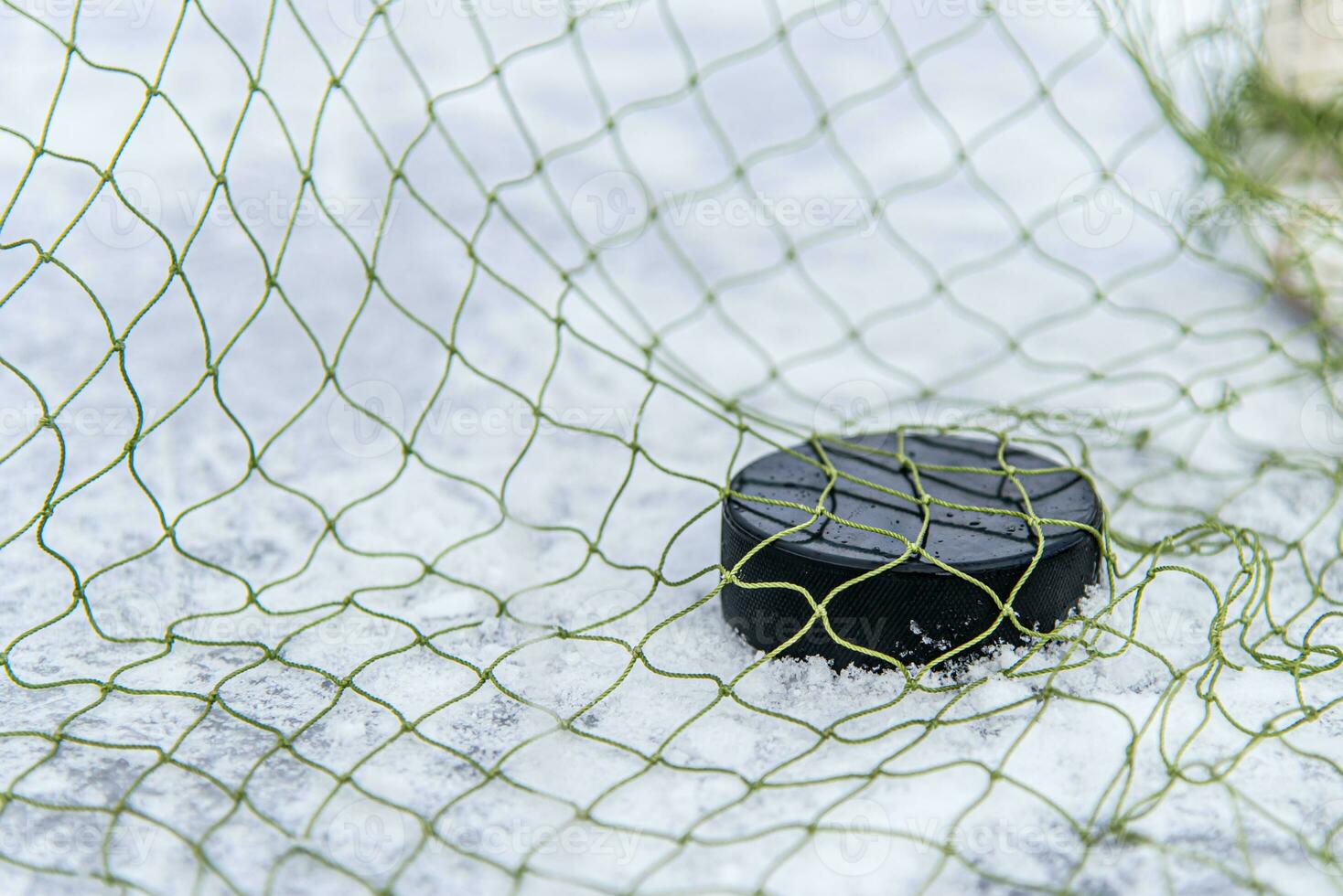 hockey puck i de mål netto närbild foto