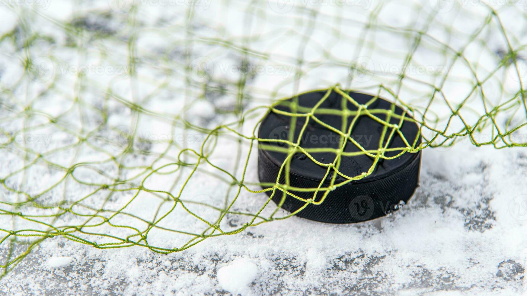 hockey puck i de mål netto närbild foto