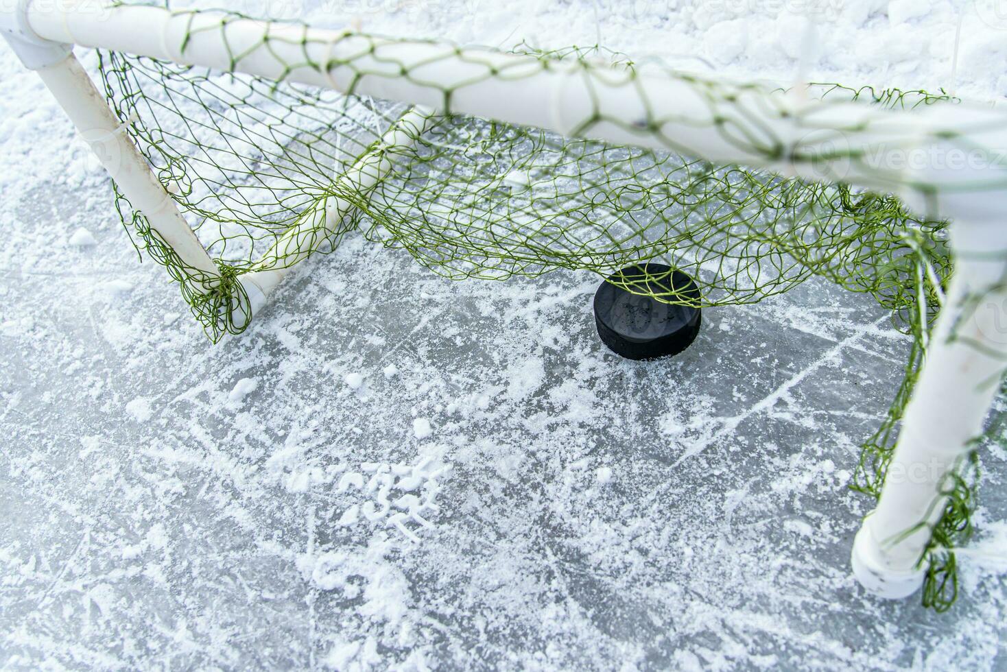 hockey puck i de mål netto närbild foto