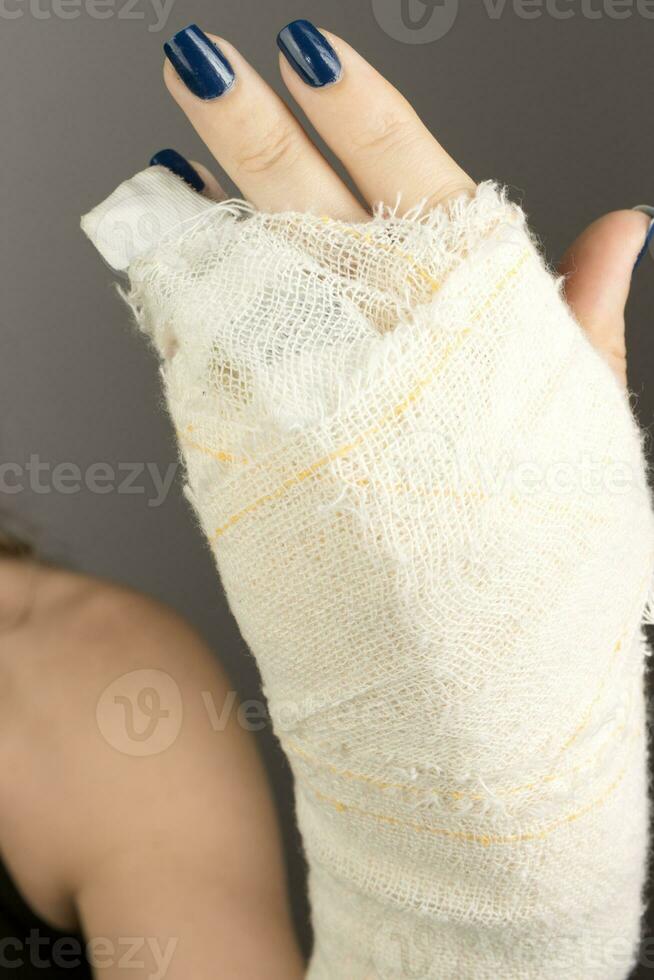 ung lady med en bandage på henne hand var hon pank henne liten finger foto