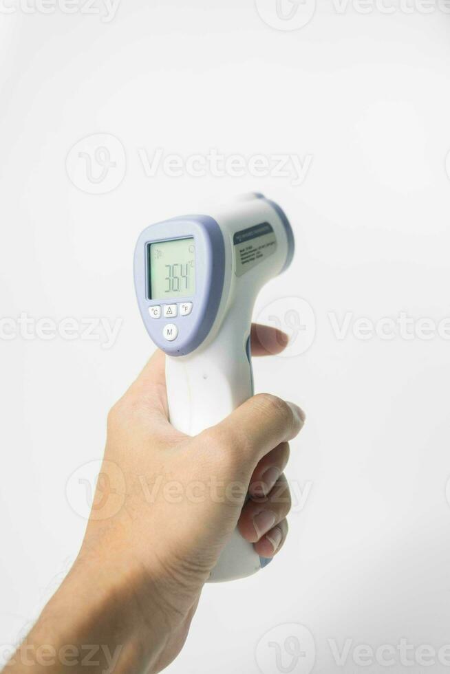 hand innehav digital infraröd termometer isolerat på vit bakgrund. med kopia Plats foto
