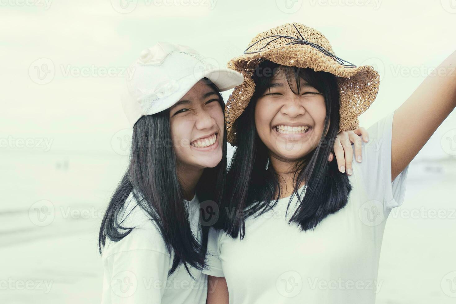toothy leende ansikte av två asiatisk tonåring lycka känsla foto