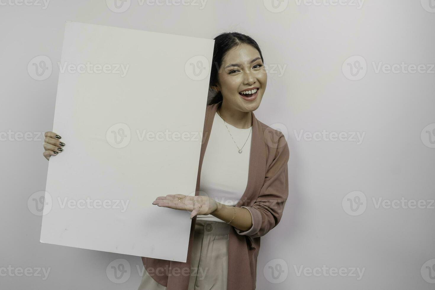 leende ung asiatisk kvinna anställd innehav och som visar tömma tom styrelse, isolerat förbi vit bakgrund foto