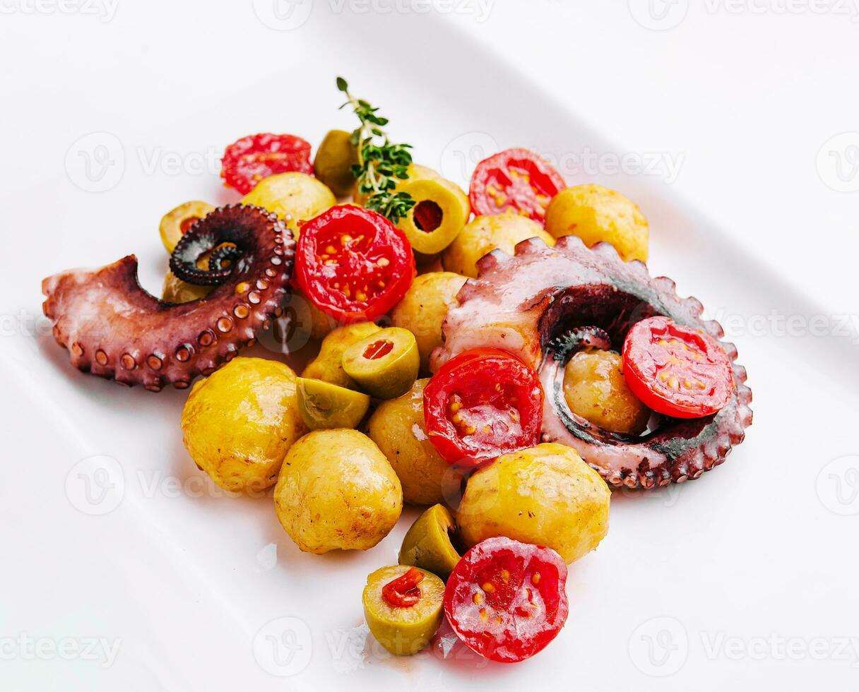 färsk bläckfisk sallad med potatisar och oliver på tallrik foto