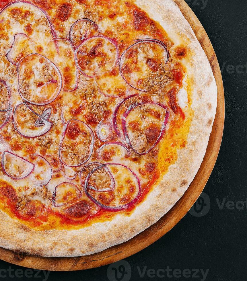 pizza med tonfisk och röd lök på trä- skärande styrelse foto