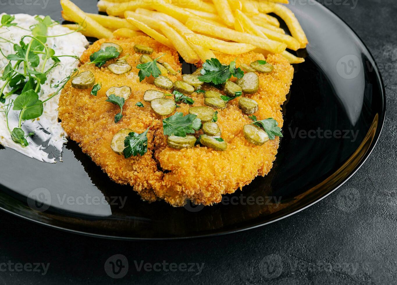 utsökt wiener jägare schnitzel med sås och franska frites närbild på en tallrik foto