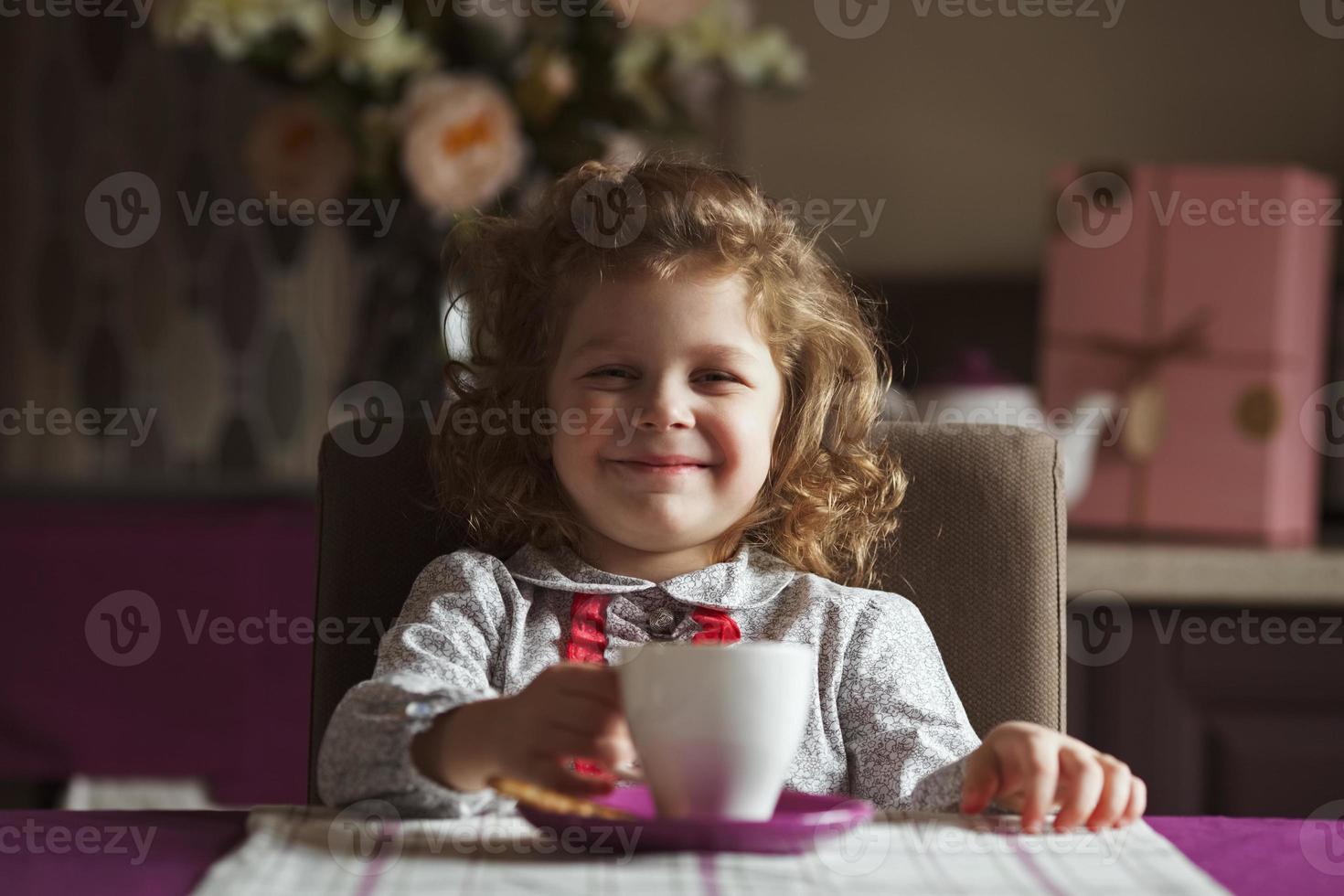 glad tjej sitter vid bordet foto