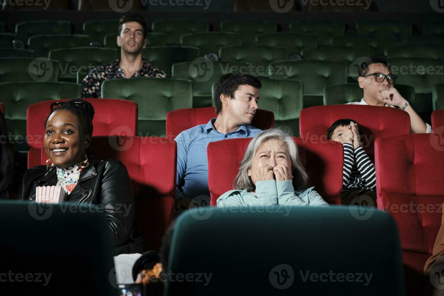 olika människor i teater. senior asiatisk kvinna och raser publik är rädd av tittar på thriller och Skräck bio, skrämd tillsammans av film, och underhållning livsstil med filma konst show. foto