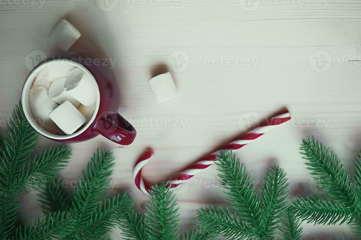 red koppar med varm choklad eller kakao och marshmallow med godis pinne. jul begrepp med gran träd grenar. närbild, selektiv fokus foto
