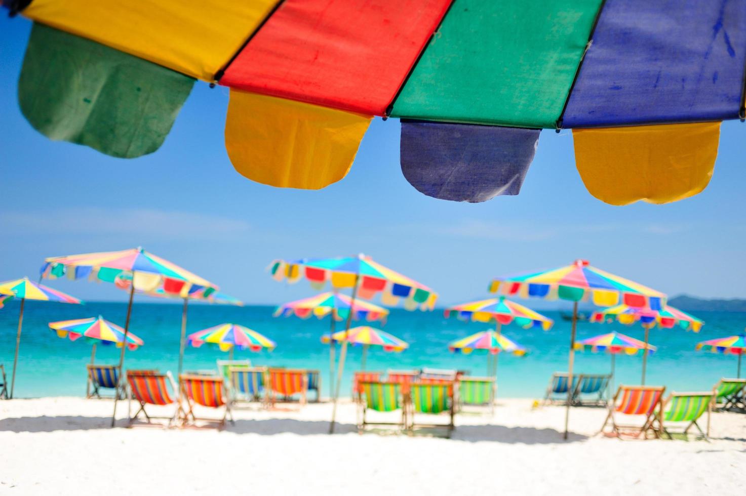 strandstol under paraplyet av färgglada på stranden phuket, thailand foto