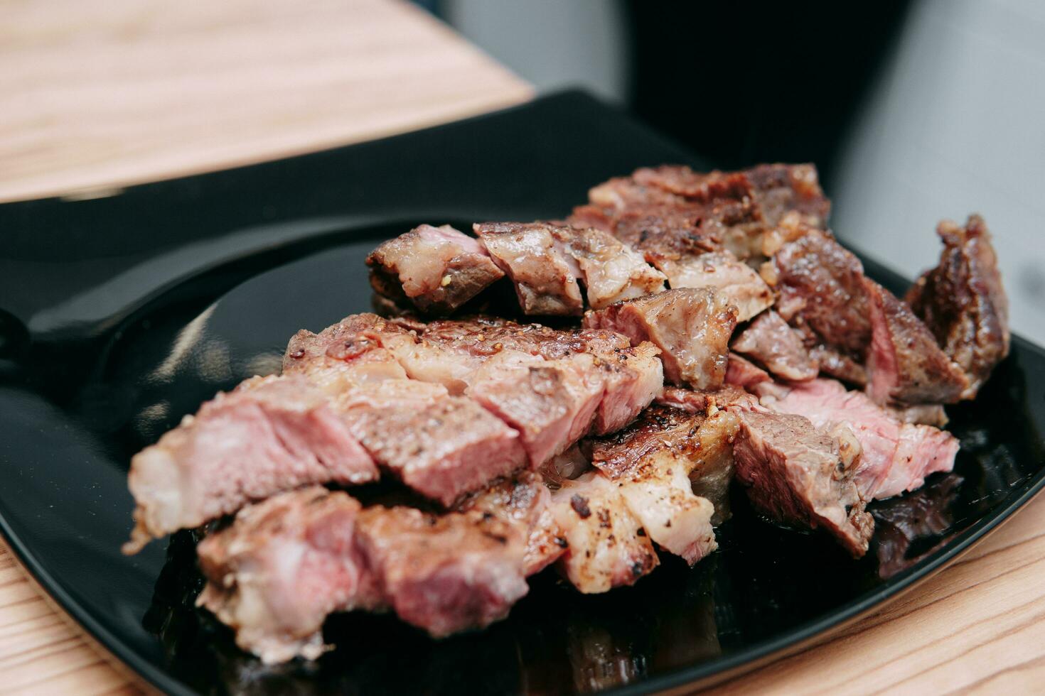 matlagning ribeye biffar och kött rullar i de matlagning klass. skivad kött på en tallrik. foto