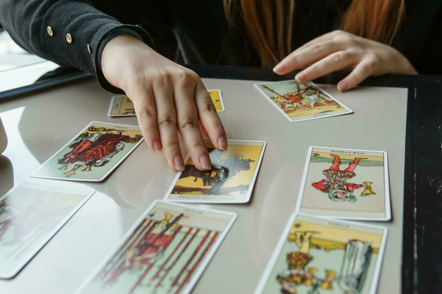 tver, ryssland - februari 11, 2023. tarot kort, tarot kort spådom, esoterisk bakgrund. en kvinna gör en layout på de kort på de tabell. spådom, förutsägelser på tarot kort. foto