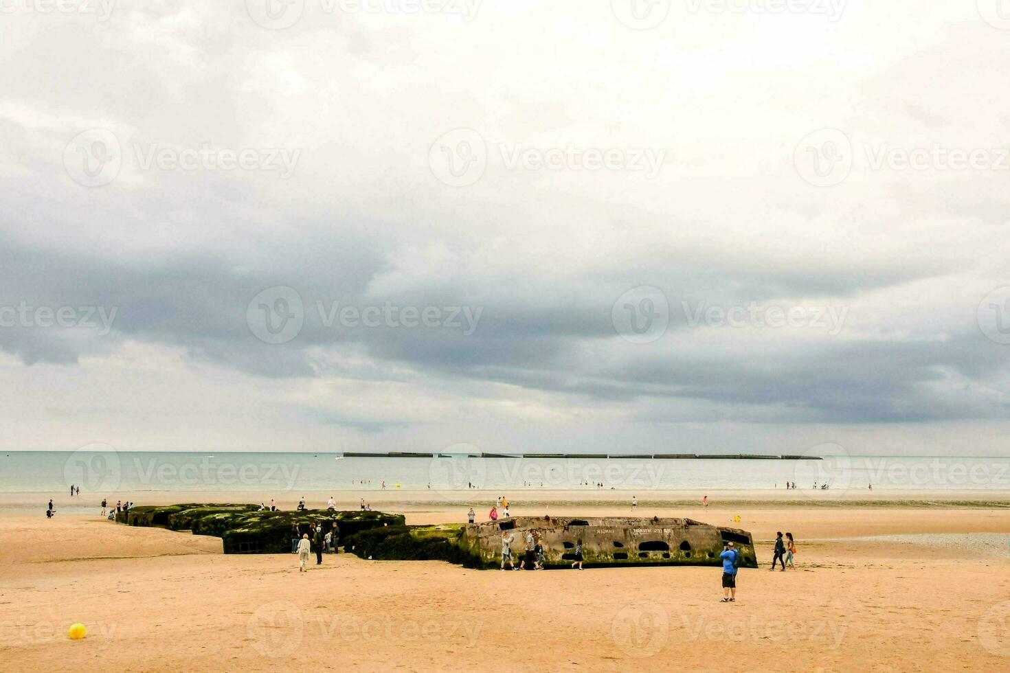 människor gående på de strand nära en stor strukturera foto