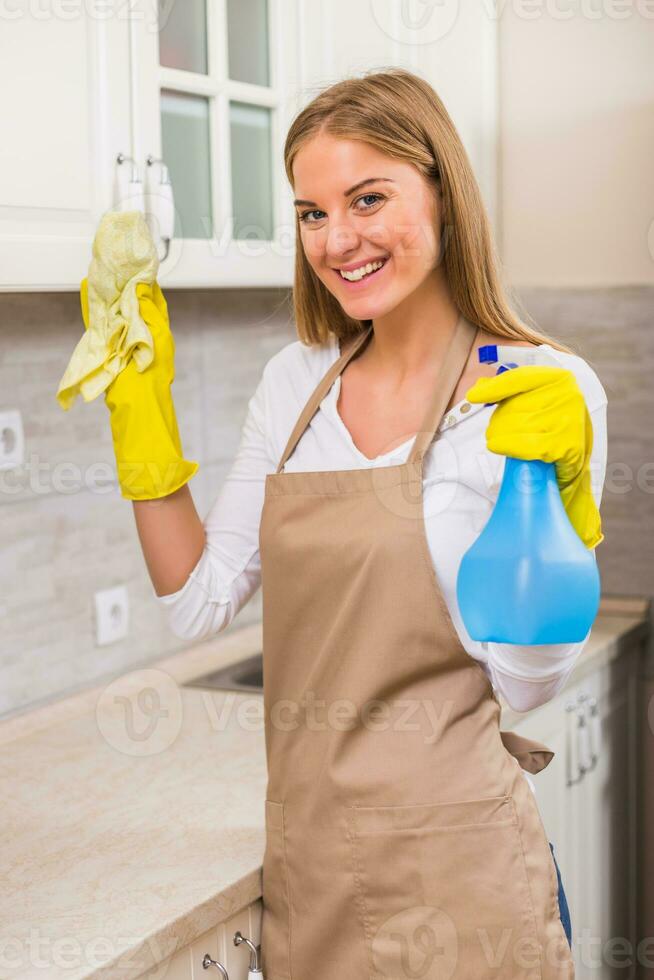 skön hemmafru åtnjuter rengöring henne kök foto