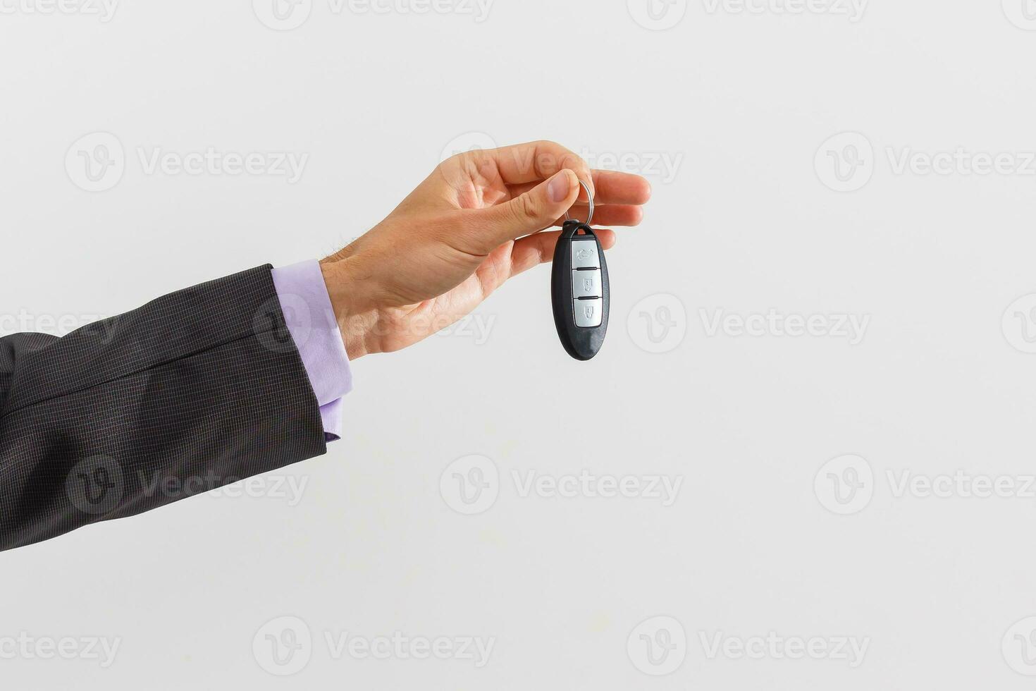 en affärsman erbjudande en knippa av bil nycklar och bil larm systemet foto