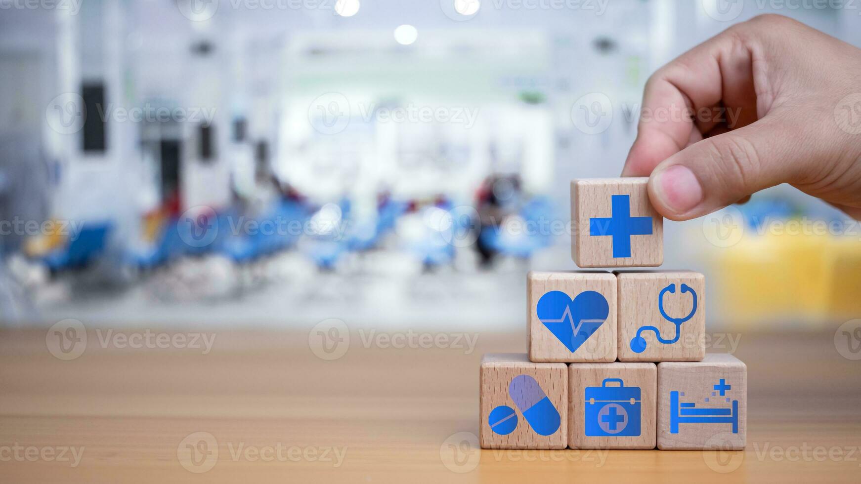 hälsa försäkring och sjukvård begrepp, mänsklig hand innehar trä- blockera med ikoner handla om hälsa försäkring och sjukvård tillgång, pensionering planera på trä- bakgrund. foto