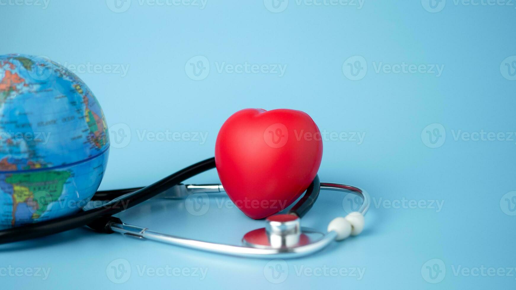 begrepp av hälsa försäkring och medicinsk välfärd, modell klot och röd hjärta med stetoskop på blå bakgrund, hälsa försäkring och tillgång till sjukvård. foto