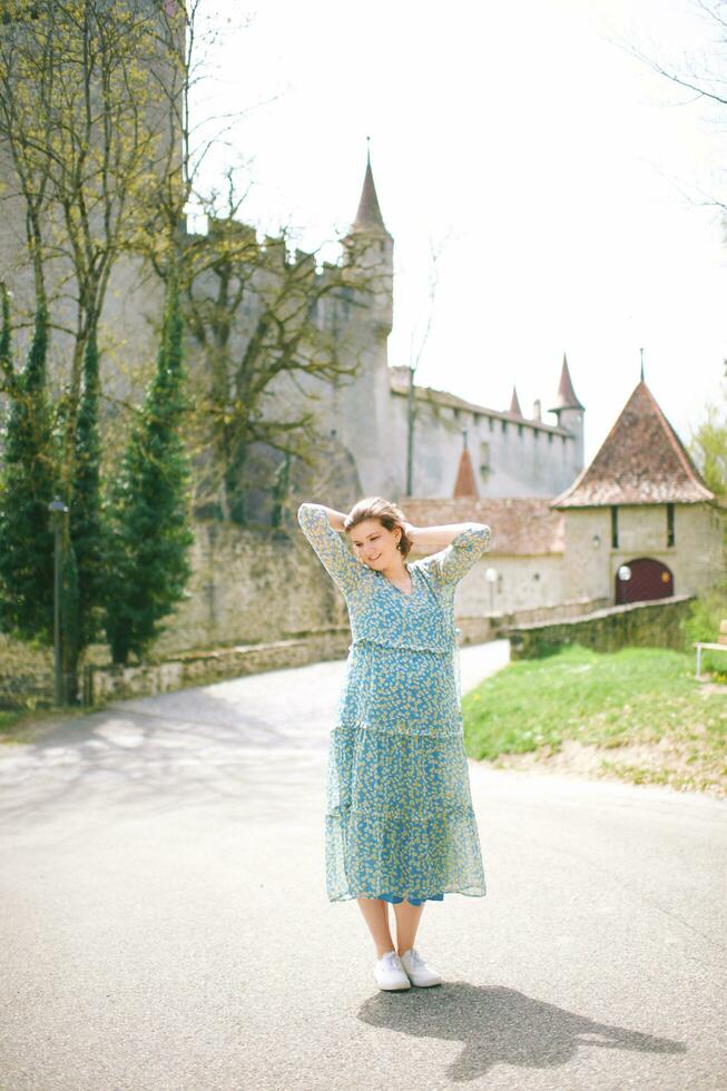 utomhus- porträtt av Lycklig ung kvinna resa i Europa, besöker gammal slott, bild ta i schweiz foto