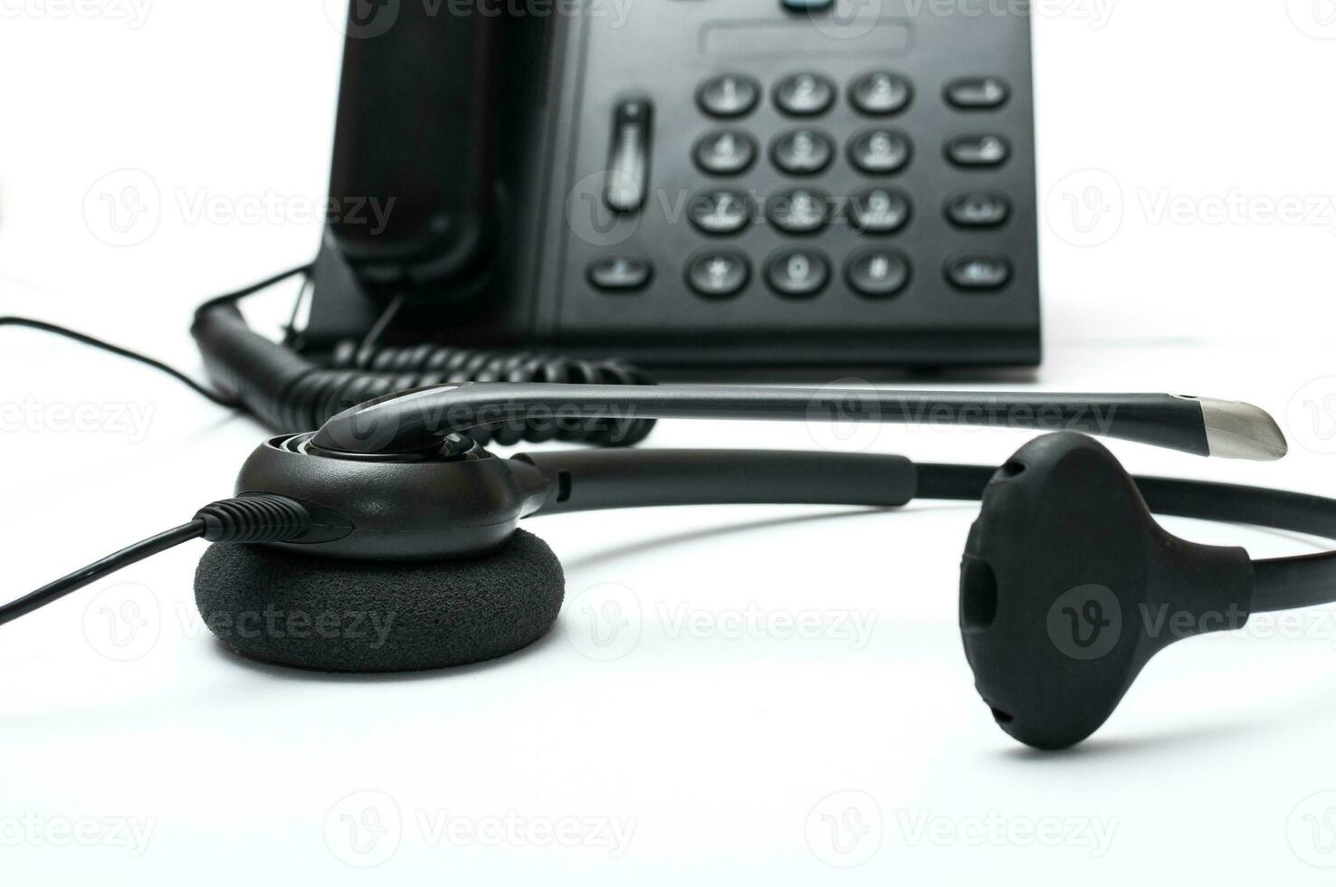 svart skrivbordet telefon med en headsetet på de vit bakgrund foto