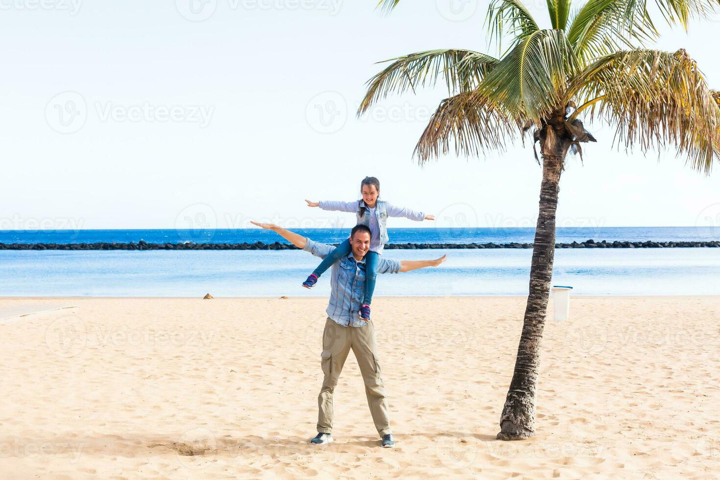 Lycklig familj händer upp på de strand foto