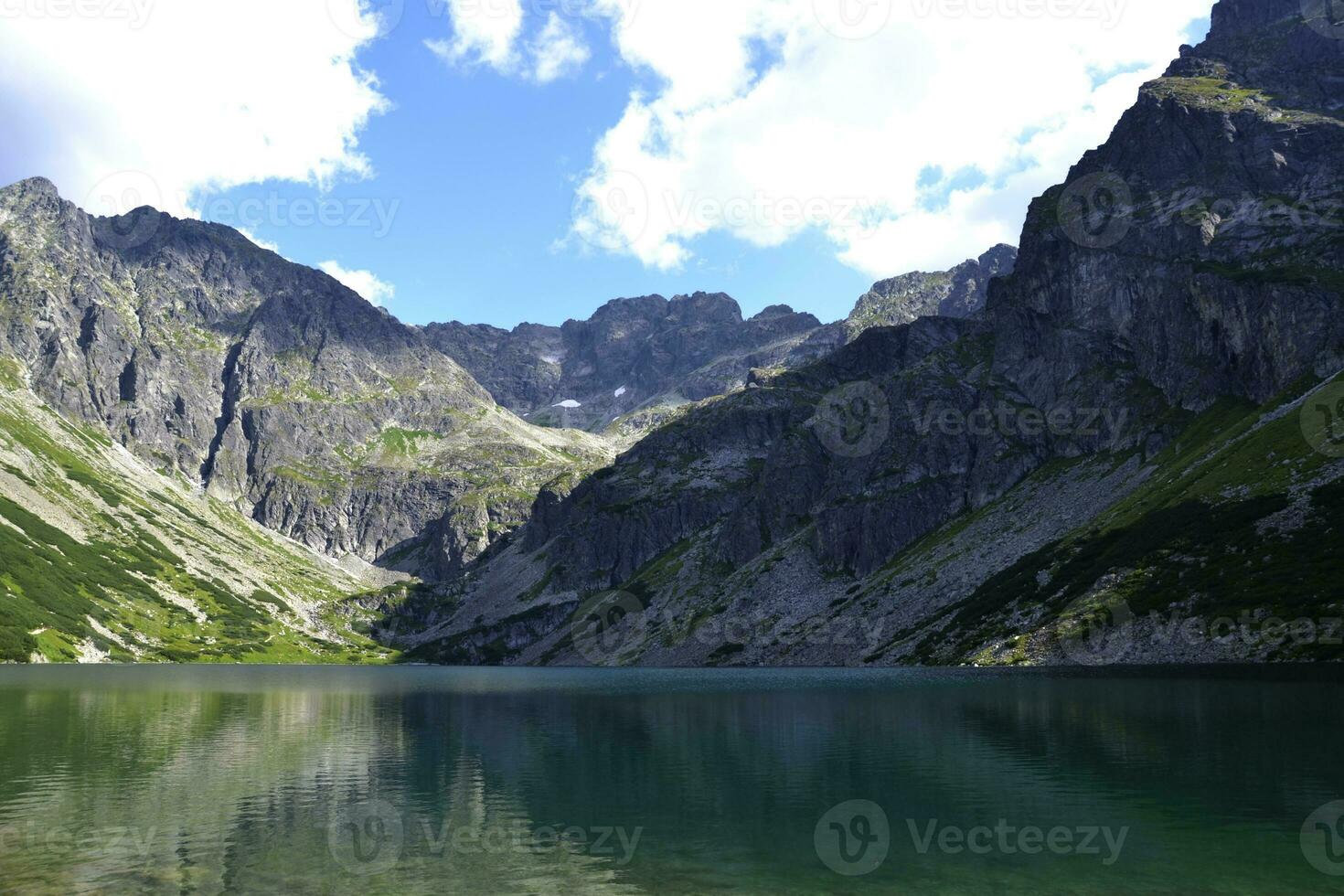 en grön vatten sjö i berg, molnig väder. 'tsarny staw gasienicowy' sjö i tatry, polen foto