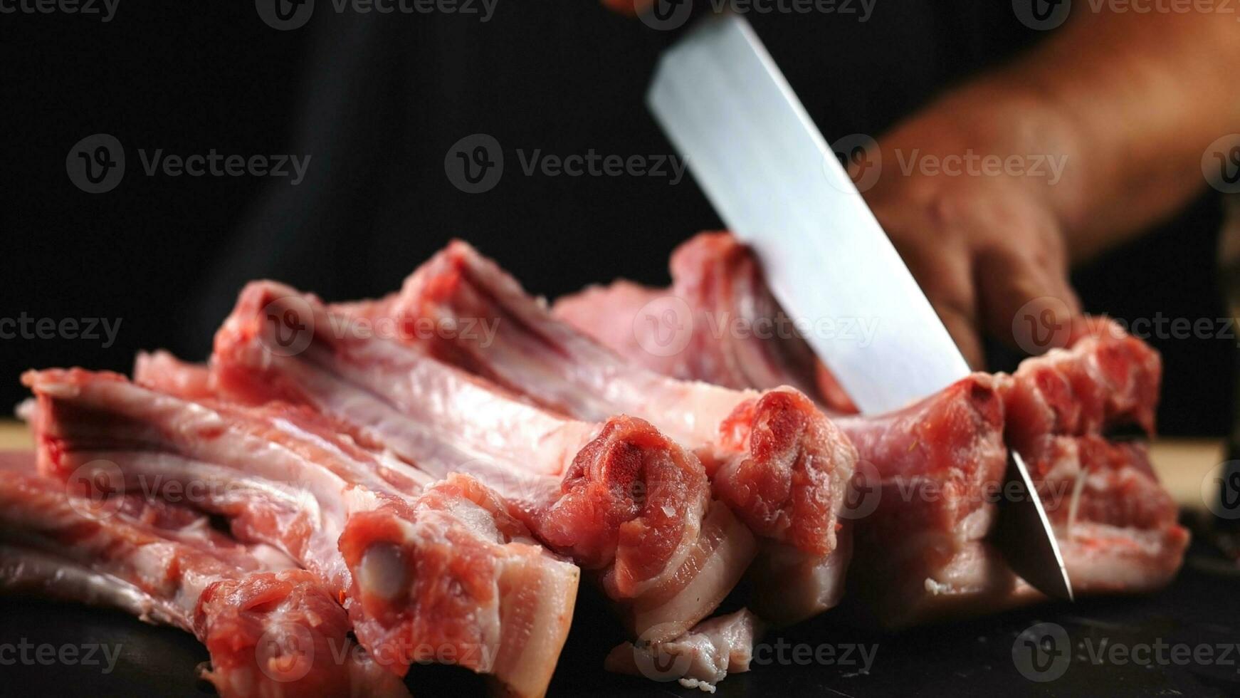 de kock nedskärningar rå kött, bbq revben med en kniv. rå nötkött skivad på en trä- styrelse. utsökt mat begrepp foto