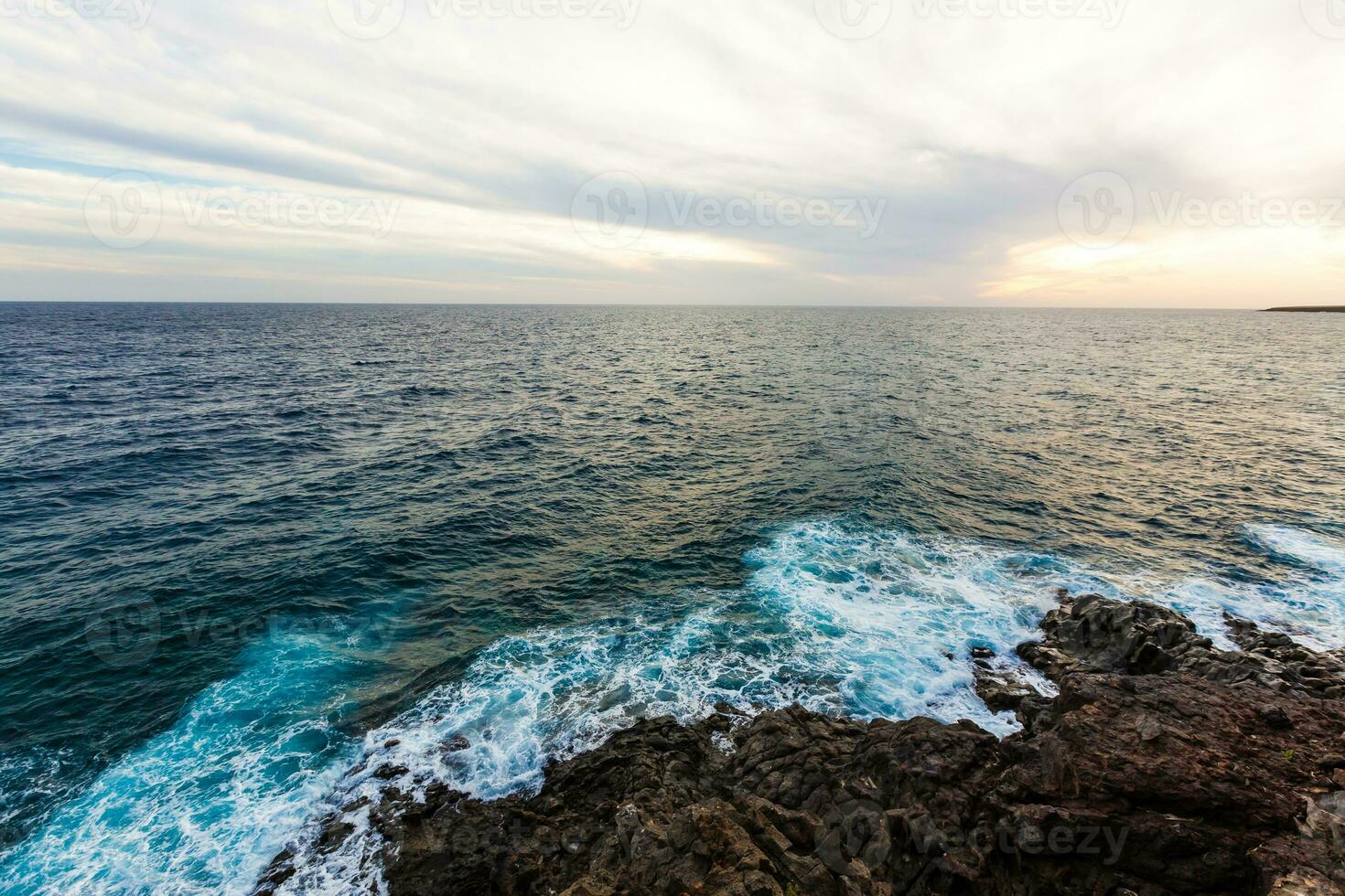 hav vågor träffa och krascha mot stenar foto