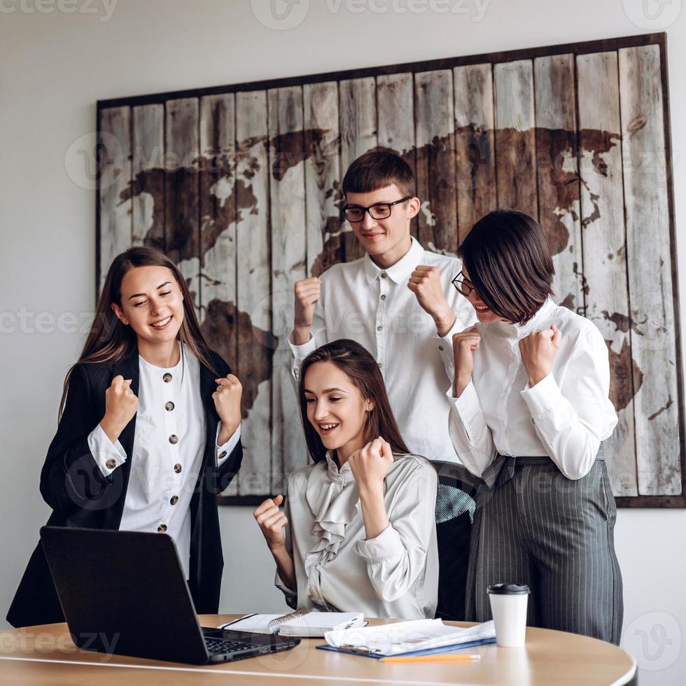 en grupp affärsmän som arbetar på ett kontor vid ett gemensamt möte gör en vinnande gest foto