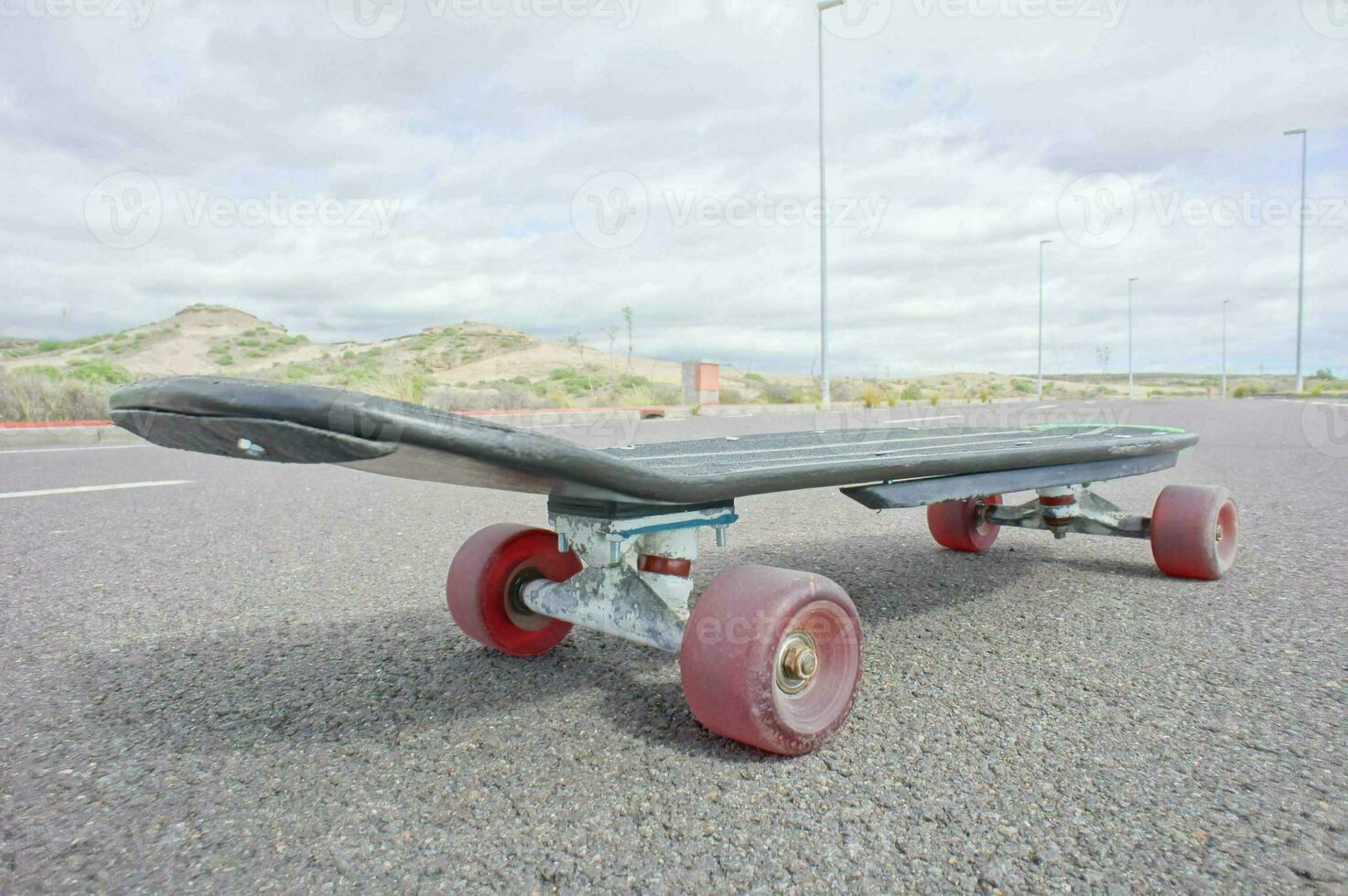 en skateboard med röd hjul Sammanträde på de jord foto